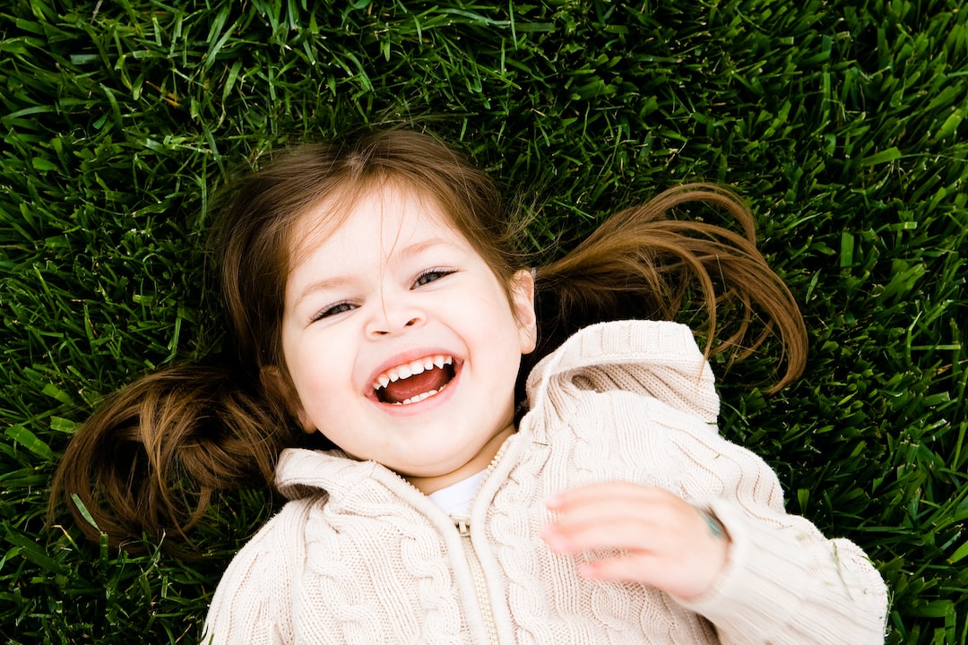 girl smiling while lying on grass field at daytime ifM0755GnS0 jpg
